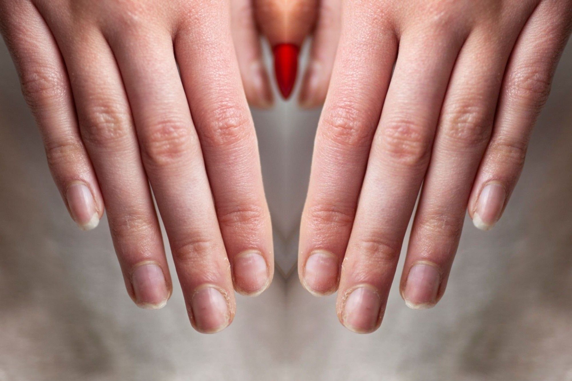 A client’s bare natural nails, short and unpolished, before her manicure