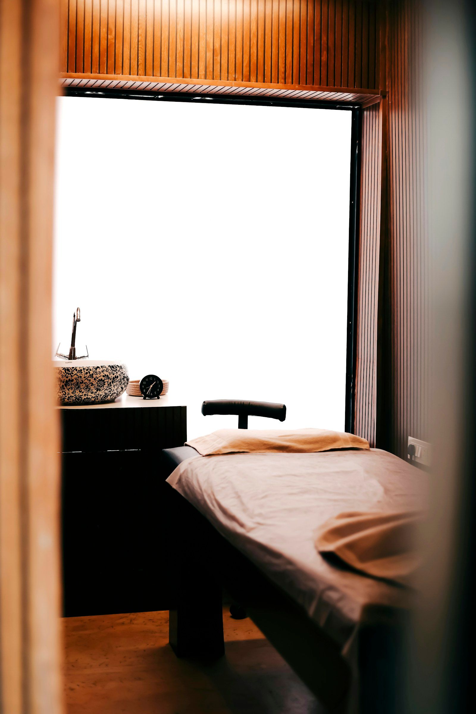 The treatment room: a made-up bed beside a window with soft daylight