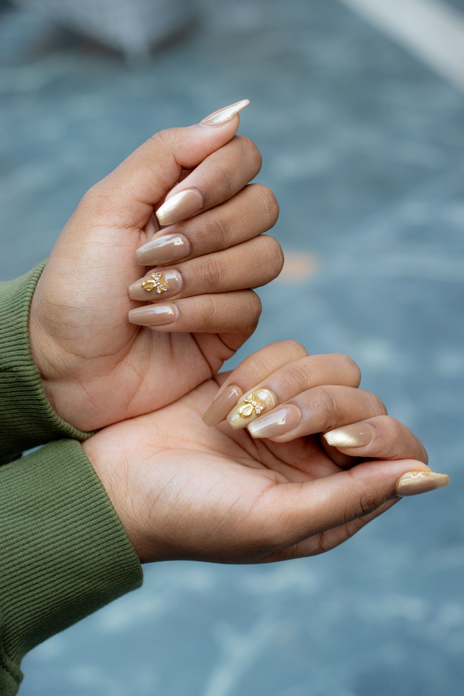 Nude almond with a gold-leaf French and a single charm