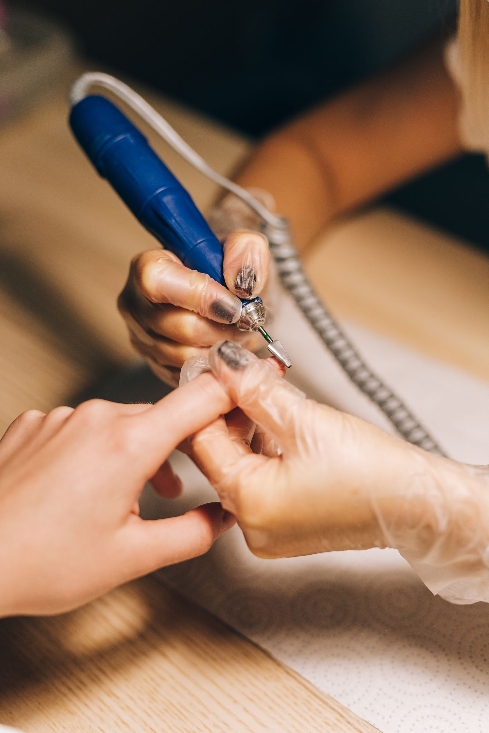 An artist refining a nail with an electric file